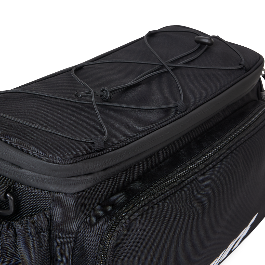 Close-up view of the top of the Murf Big Dawg Rack Bag, highlighting the bungee cord straps for securing extra lightweight gear.