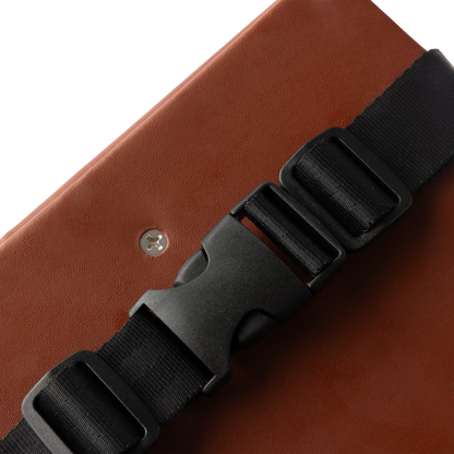 Close-up of the Murf Cargo Seat Pad, highlighting the brown synthetic leather texture and the black nylon quick release buckle clasp mechanism.