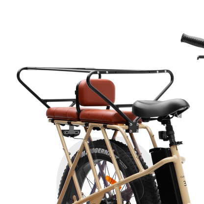 Brown Murf Cargo Seat Pad accessory installed on the rear rack of a tan Murf e-bike, demonstrating comfortable passenger seating and secure mounting with a safety rail.