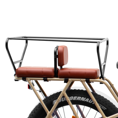 Side view of Brown Murf Cargo Seat Pad accessory installed on the rear rack of a tan Murf e-bike, demonstrating comfortable passenger seating and secure mounting with a safety rail.