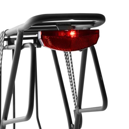 Close-up view of the Murf Rear Rack's integrated rear tail light, showing the bright red LED illuminated for visibility and road safety.