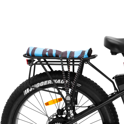 Rear Rack Package mounted on a Murf E-Bike, demonstrating secured cargo (rolled towel) using the bungee strap and highlighting the integrated rear light and fat tire.