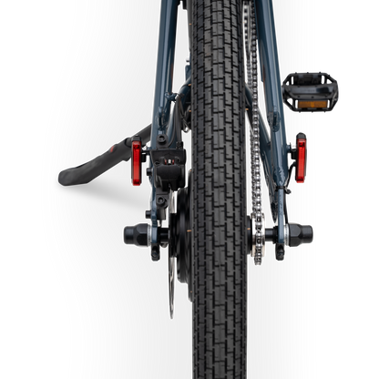 Rear view of The Otis E-Bike in Marine Blue showing tire tread, rear hub motor, and integrated safety lights